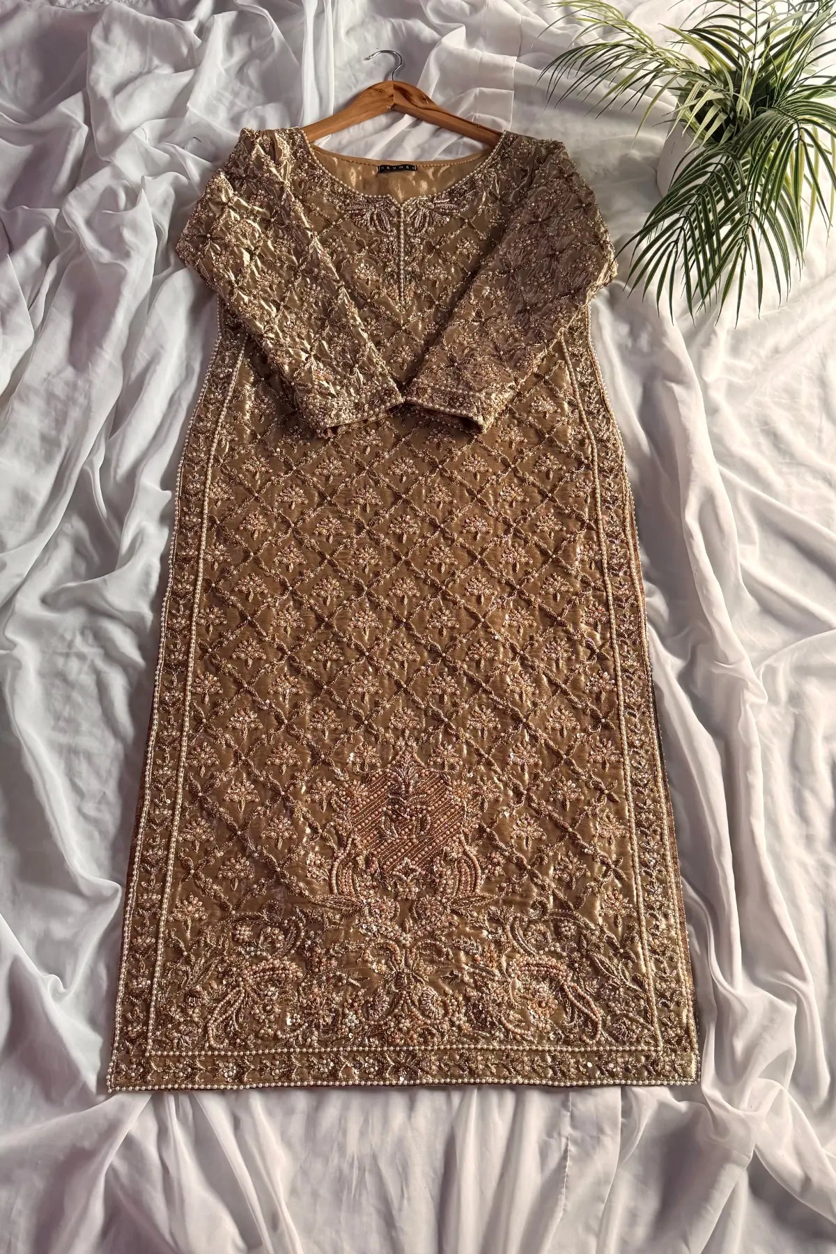 Brown patterned dress on a hanger against a white fabric background