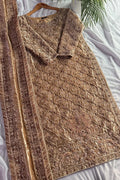 Brown embroidered dress on a white surface with a hanger