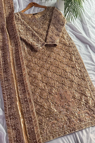 Brown embroidered dress on a white surface with a hanger